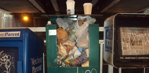 trash can in the middle of newsstands