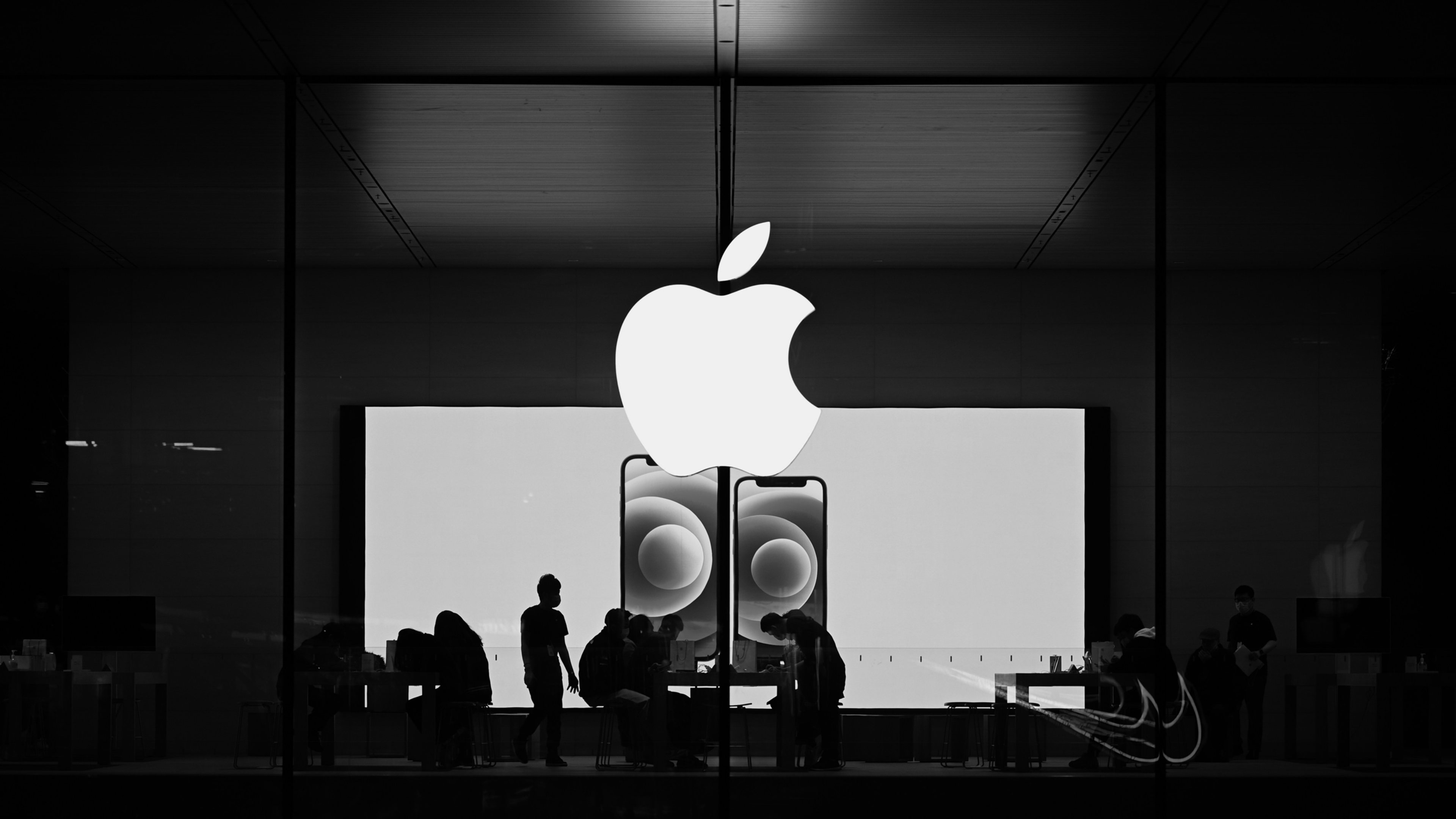 Apple logo with store behind in black and white.