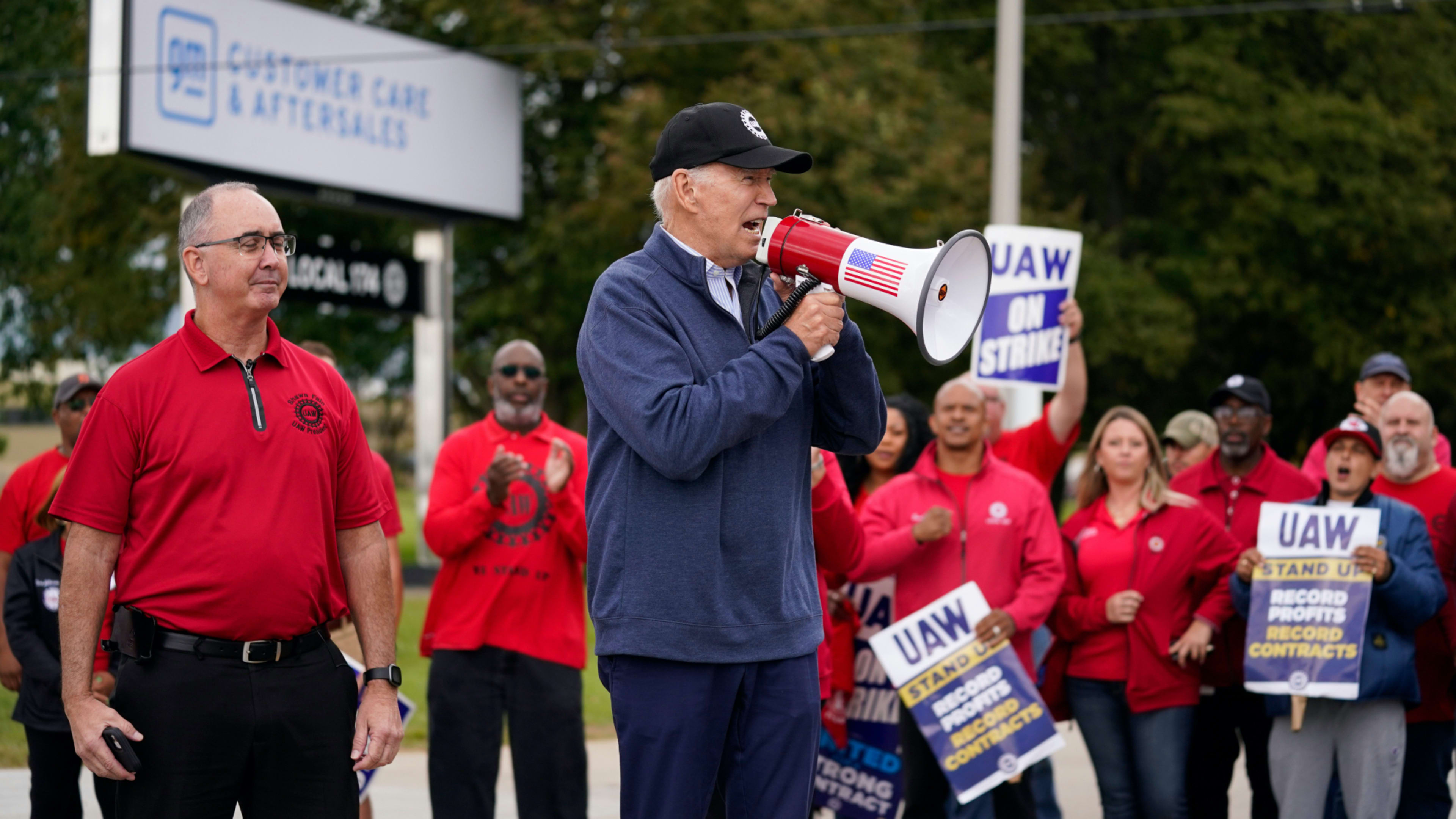 President Joe Biden joins striking United Auto Workers on the picket line, Tuesday, Sept. 26, 2023, in Van Buren Township, Mich. United Auto Workers President Shawn Fain stands at left.