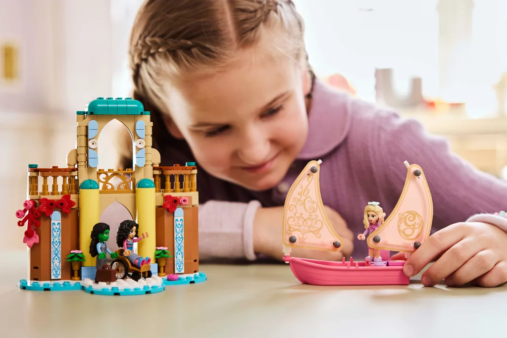 A girl playing with a Lego Wicked set.