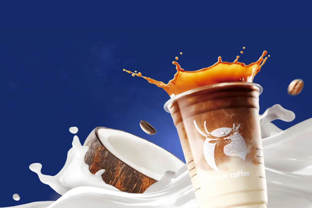 A Luckin Coffee brand image depicting a cold beverage spilling upward in front of coconut milk splashing across a blue background.