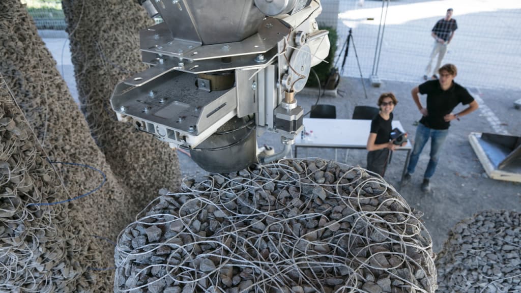 See a bizarre robot make a building out of loose rocks and string