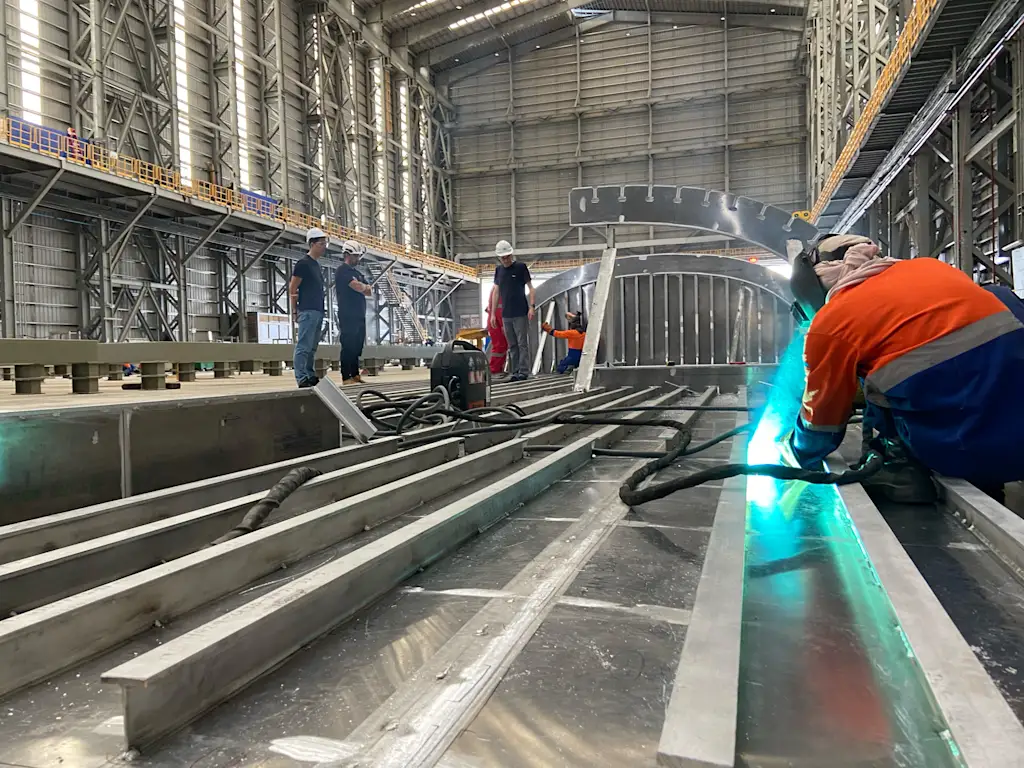 A photograph of workers building the Vela cargo ship.