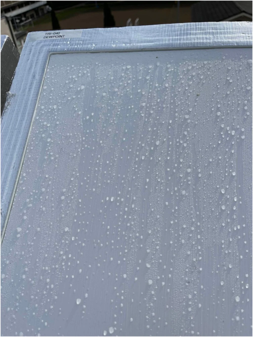 een monster van het dauwpuntmateriaal met waterdruppels erop