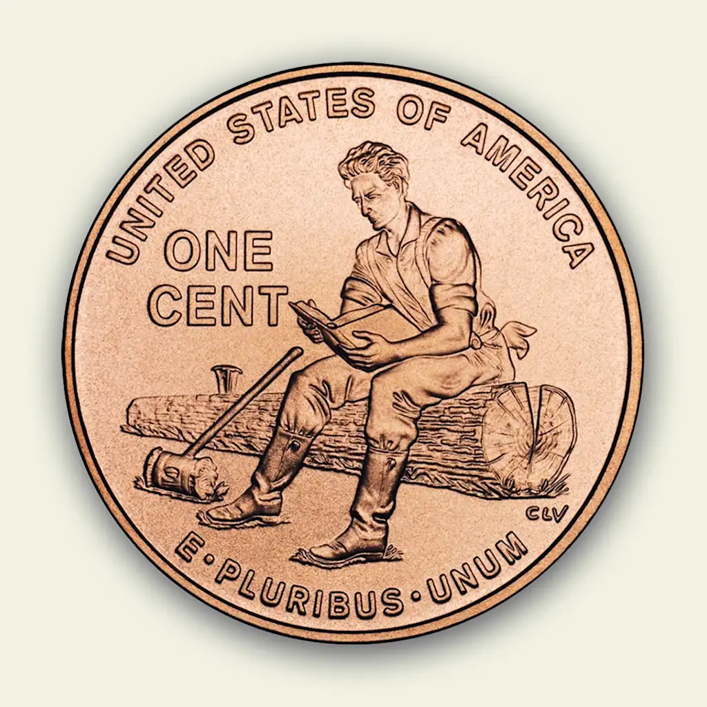 The face-side of newer penny design, featuring Abraham Lincoln sitting on a log and reading a book next to a mallet.