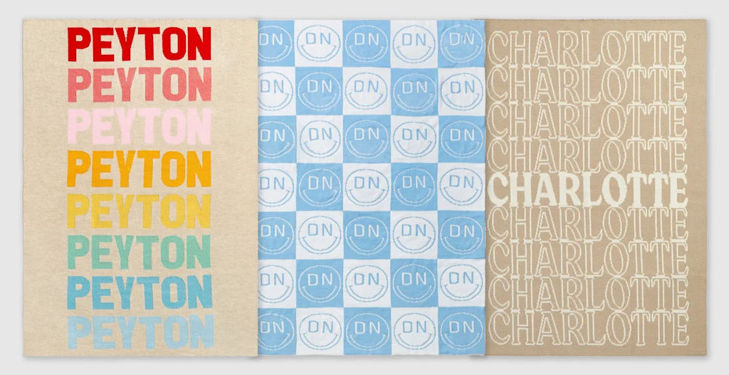 A series of blankets that have been customized with names or initials in repeating paterns