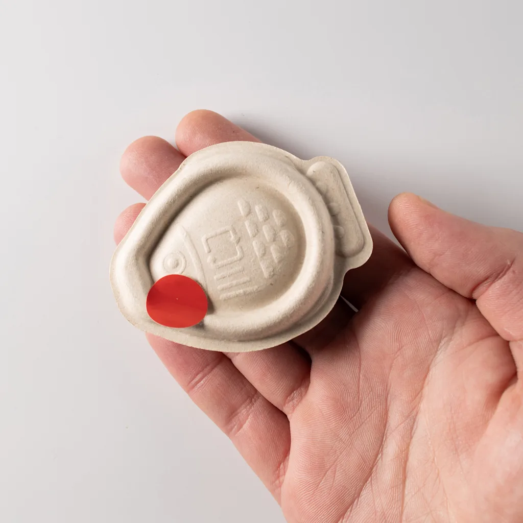 A hand holds a Holy Carp soy sauce dropper.