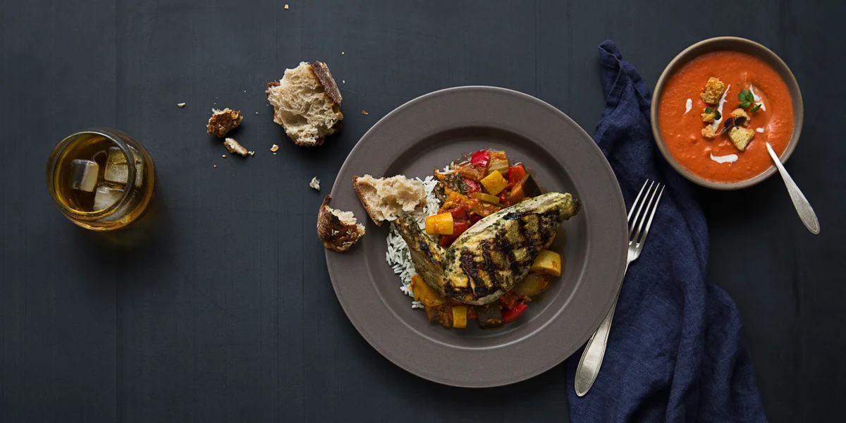 Munchery promotional photograph of grilled chicken, vegetables, rice, and soup