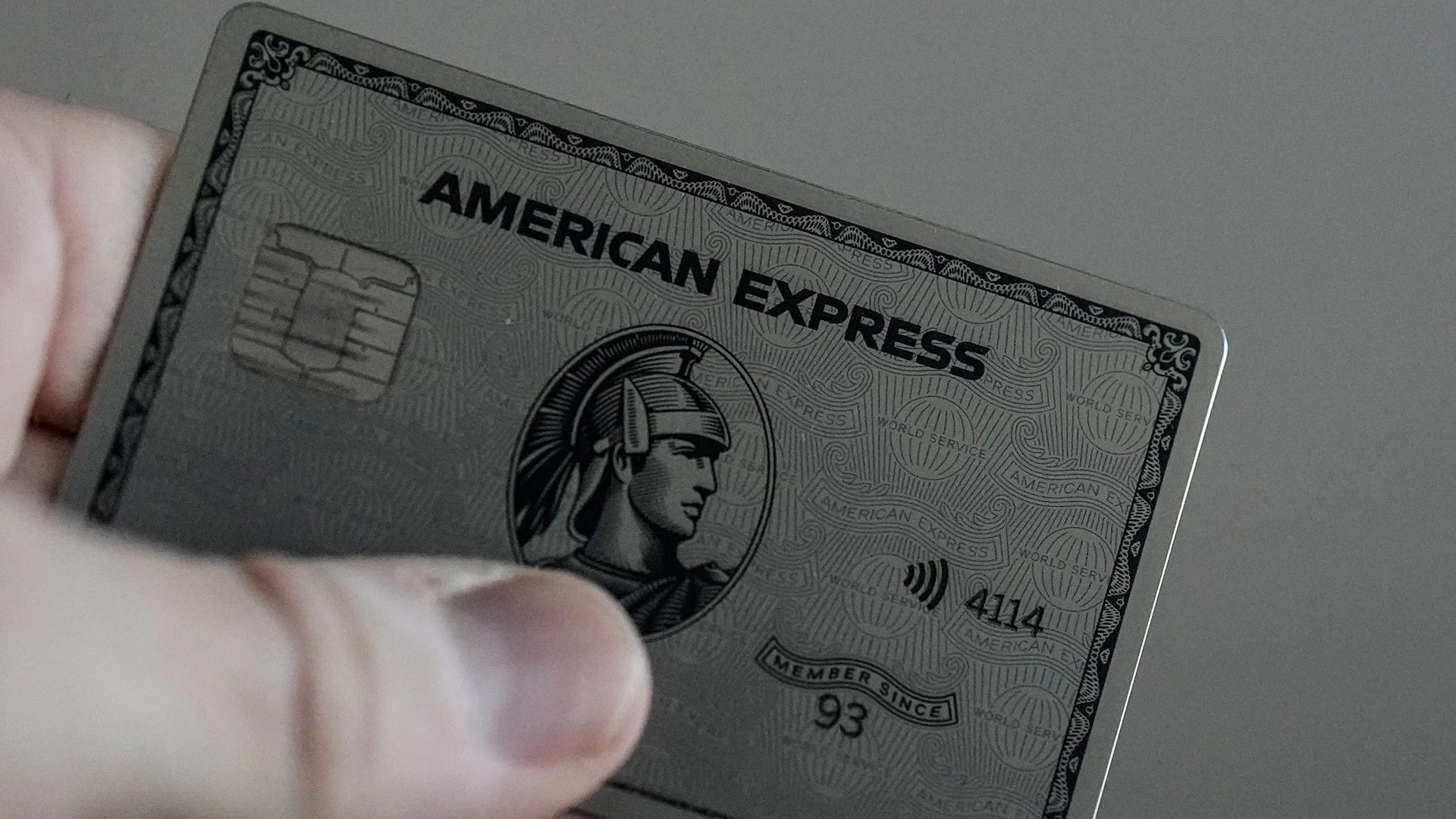 someone holding a silver american express card in their hand