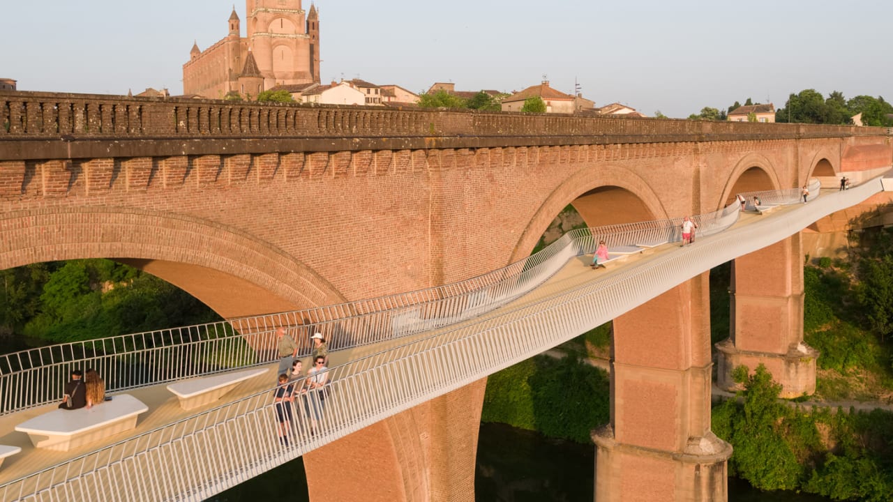 This stunning new bike and pedestrian crossing hangs off the side of an old railroad bridge