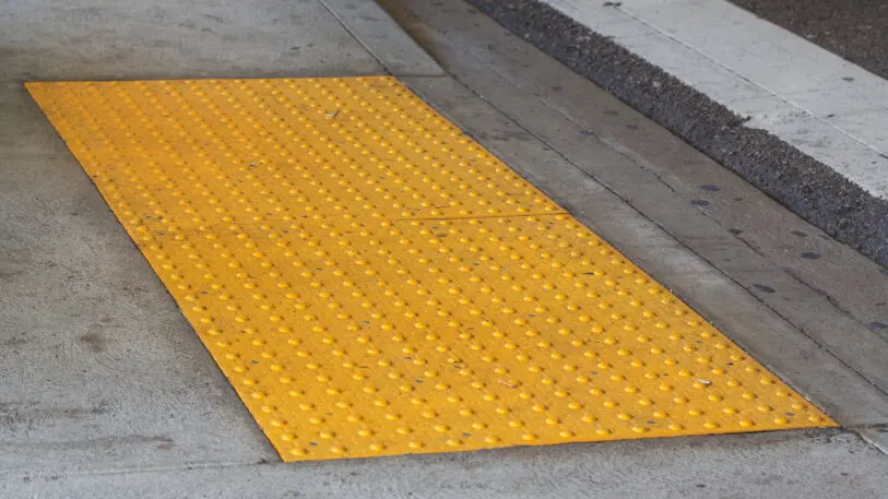 A photo of tactile paving at a crosswalk.