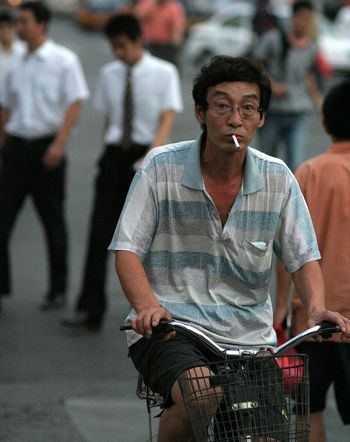 Chinese man riding bike and smoking